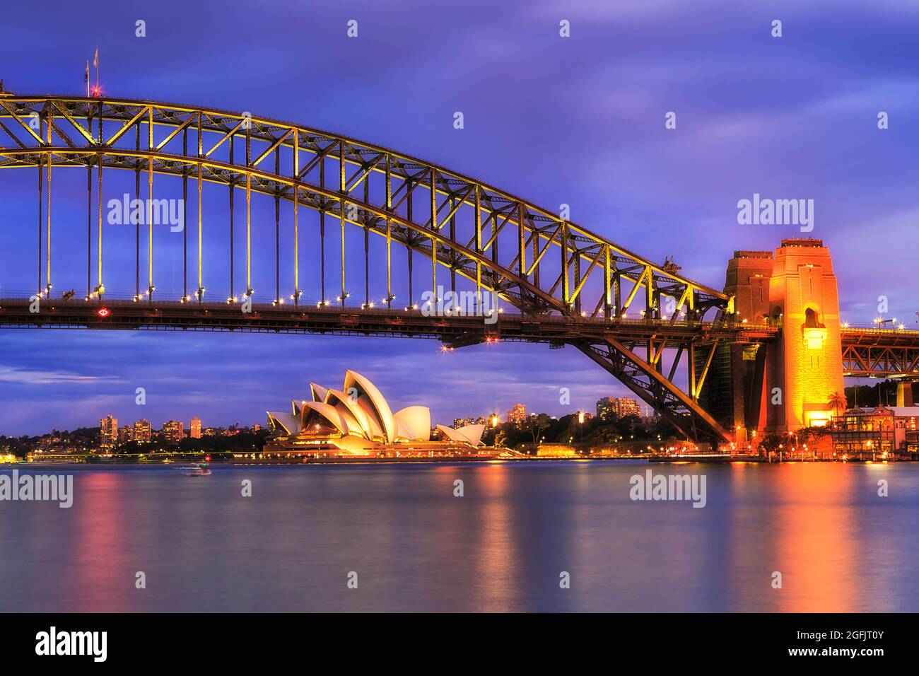 Fragment of Sydney Harbour bridge steel construct over Sydney harbour to The Rocks at sunset in bright illumination. Stock Photo