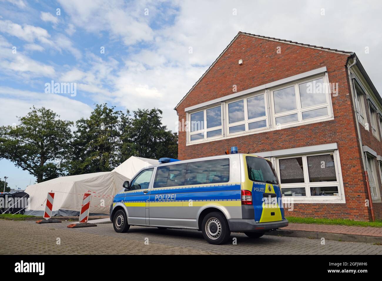 Schortens, Germany. 26th Aug, 2021. A police car stands in front of the vaccination centre. In the morning hours, officers searched several buildings of the German Red Cross (DRK) in Friesland. The Soko 'Vakzin' found further irregularities during its investigations. (to dpa 'Searches during investigations into saline injections') Credit: Markus Hibbeler/dpa/Alamy Live News Stock Photo