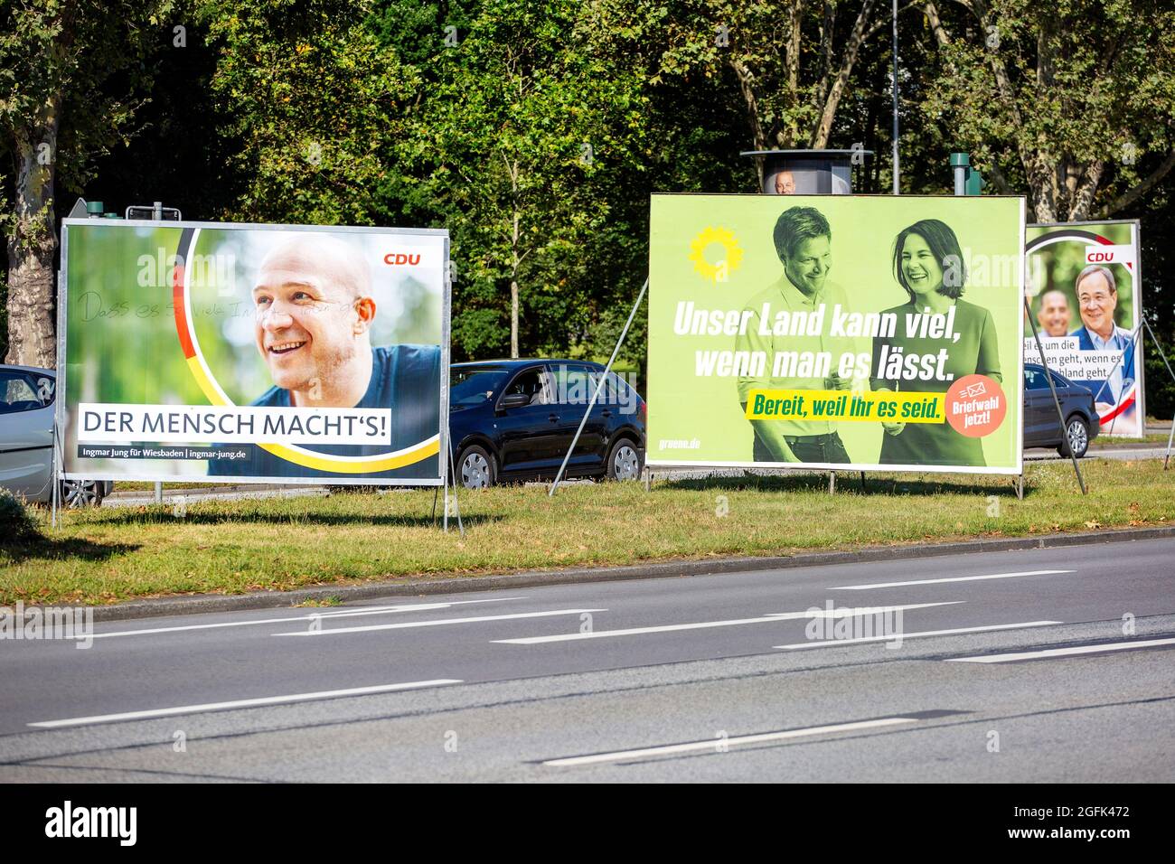 Wiesbaden, Germany - August 25, 2021: Election campaign billboards of the German party DIE GRUENEN and Christlich-Demokratische Union (CDU) in the city center of Wiesbaden, Hessen. Germany faces federal elections on September 26. Some road users in the background Stock Photo