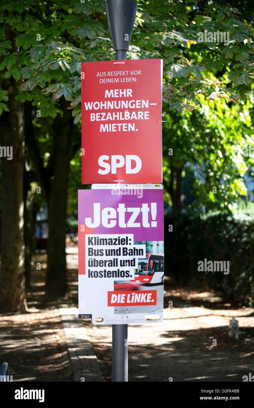 Wiesbaden, Germany - August 25, 2021: Election campaign billboards of the German party DIE LINKE (German Left party) and Social Democratic Party (SPD) in the city center of Wiesbaden, Hessen. Germany faces federal elections on September 26. Some road users in the background Stock Photo