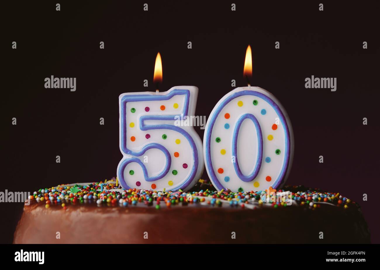 Birthday cake with burning candles on dark background Stock Photo - Alamy
