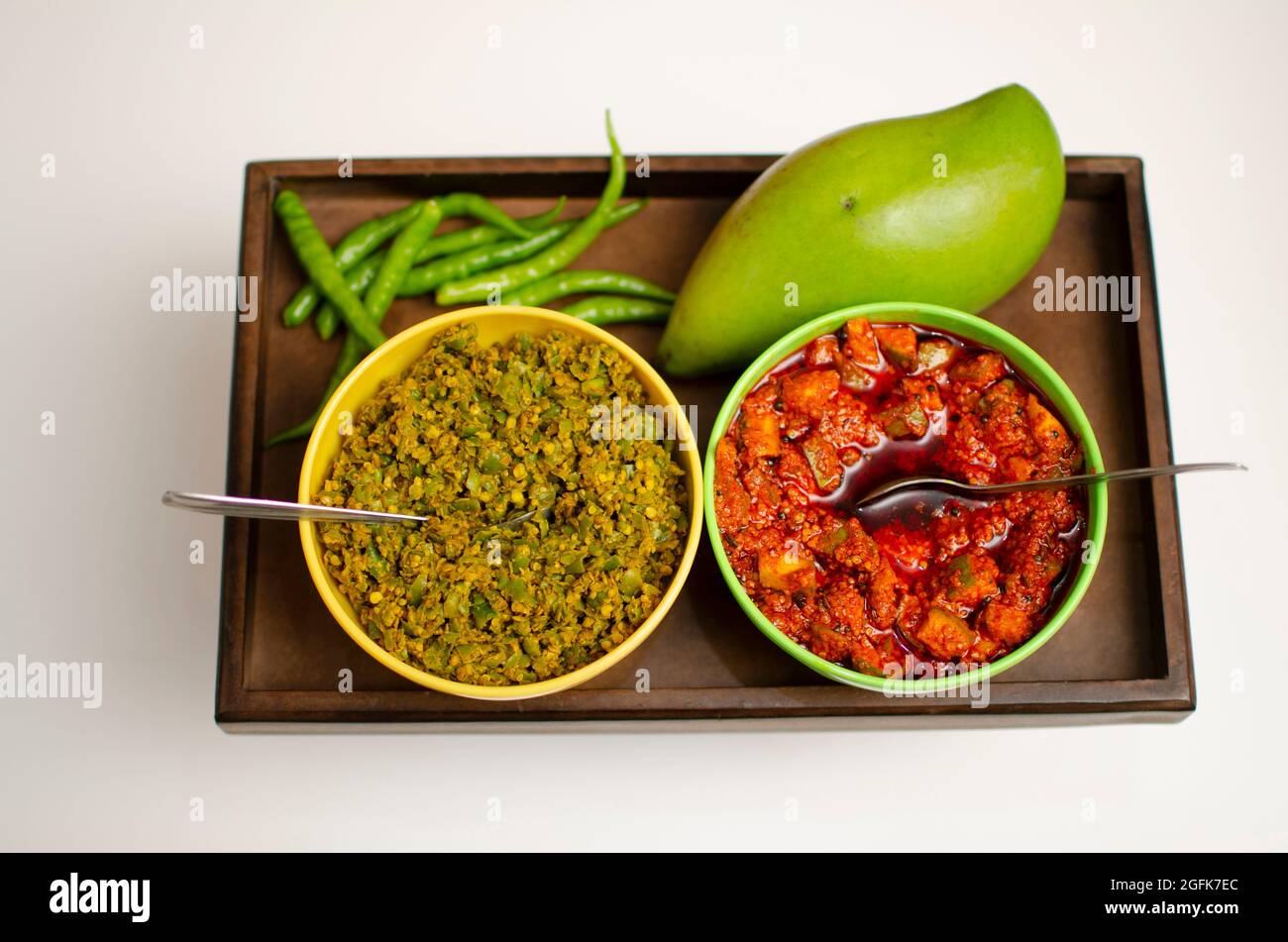 Raw Mango Pickle and  Green Chilly Pickle Achar placed on a wooden Tray Studio Shot Stock Photo