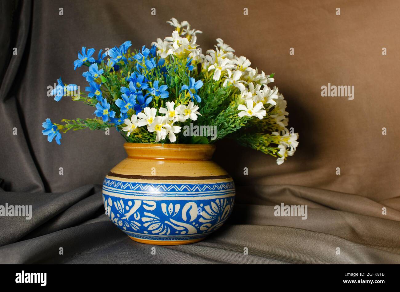 Traditional ceramic pot with Blue design and flowers on Brown background Stock Photo