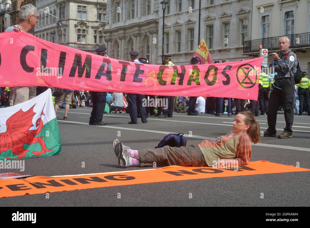 Protesters sitting on the ground blocking the road, during the demonstration. Climate change activists from Extinction Rebellion. Stock Photo