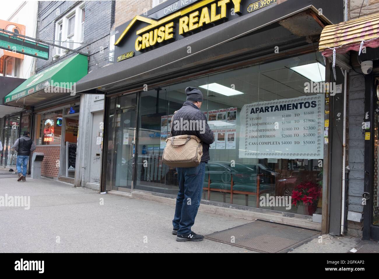 A man apartment hunting in the window of a real estate agent on
