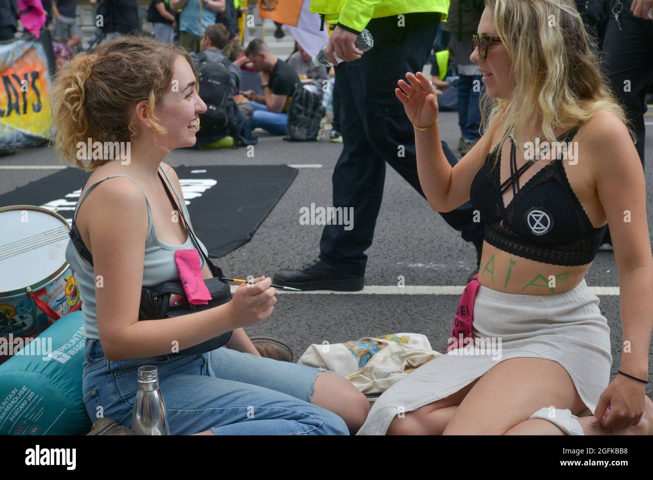 An activist having her body painted during the demonstration. Climate change activists from Extinction Rebellion demonstrate at Parliament Street. Stock Photo