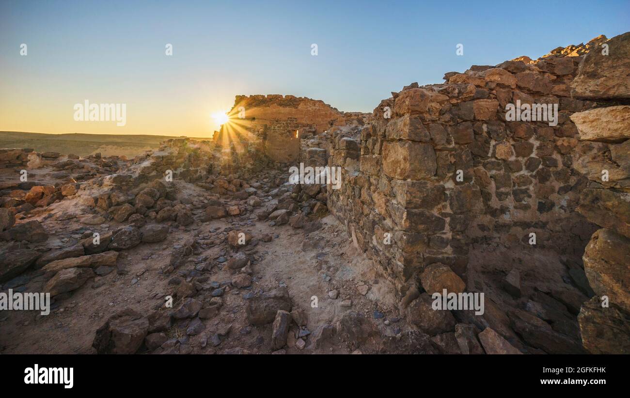 Old wall on the top of a rocky mountain during sunset in Taghit, Algeria Stock Photo