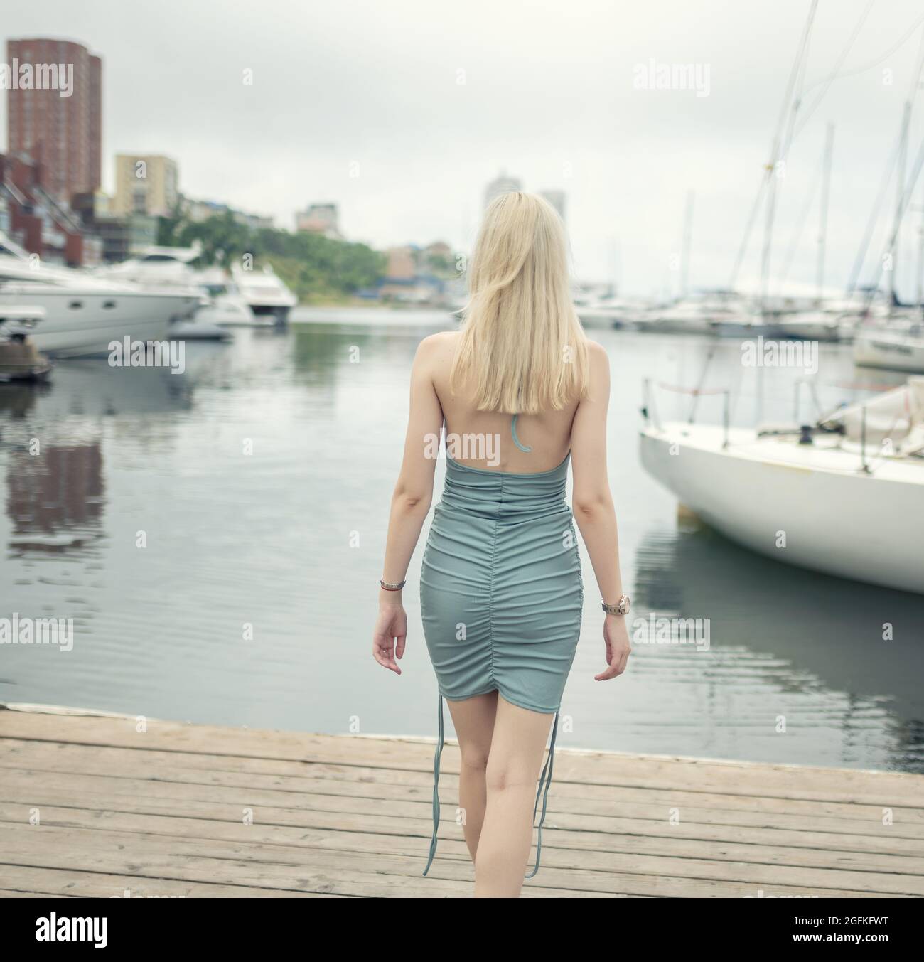 Woman in blue dress enjoys sea on the pier Stock Photo - Alamy