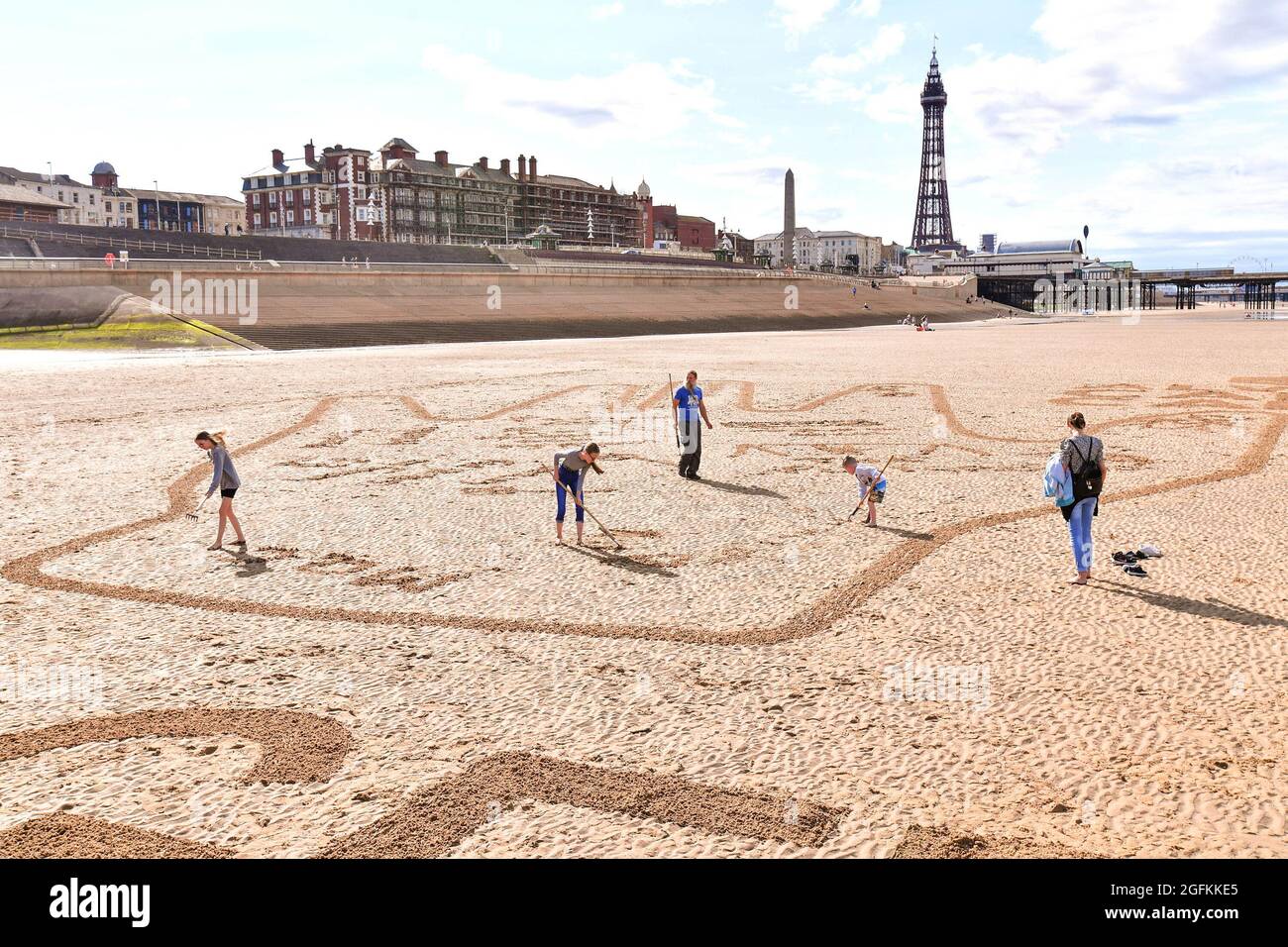 EDITORIAL USE ONLY Members of the public contribute personalised messages to their loved-ones on a 40-metre sand drawing by artists 'Sand in Your Eye', which has been created by hygiene brand Carex to encourage people to get back together safely , Blackpool. Picture date: Thursday August 26, 2021. Stock Photo