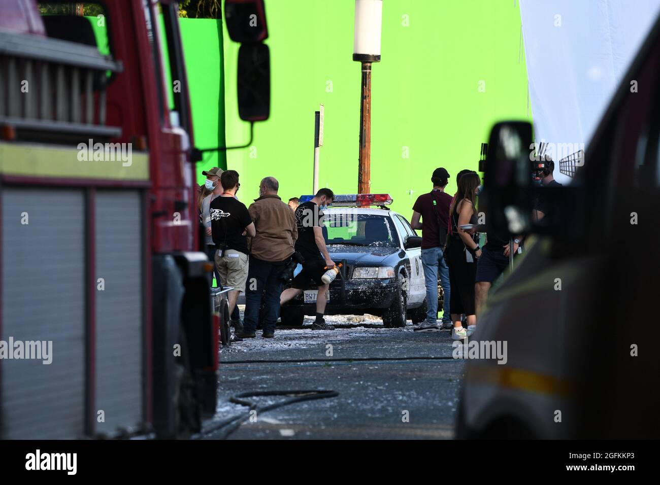 A member of crew sprays fake snow onto an American Police car during