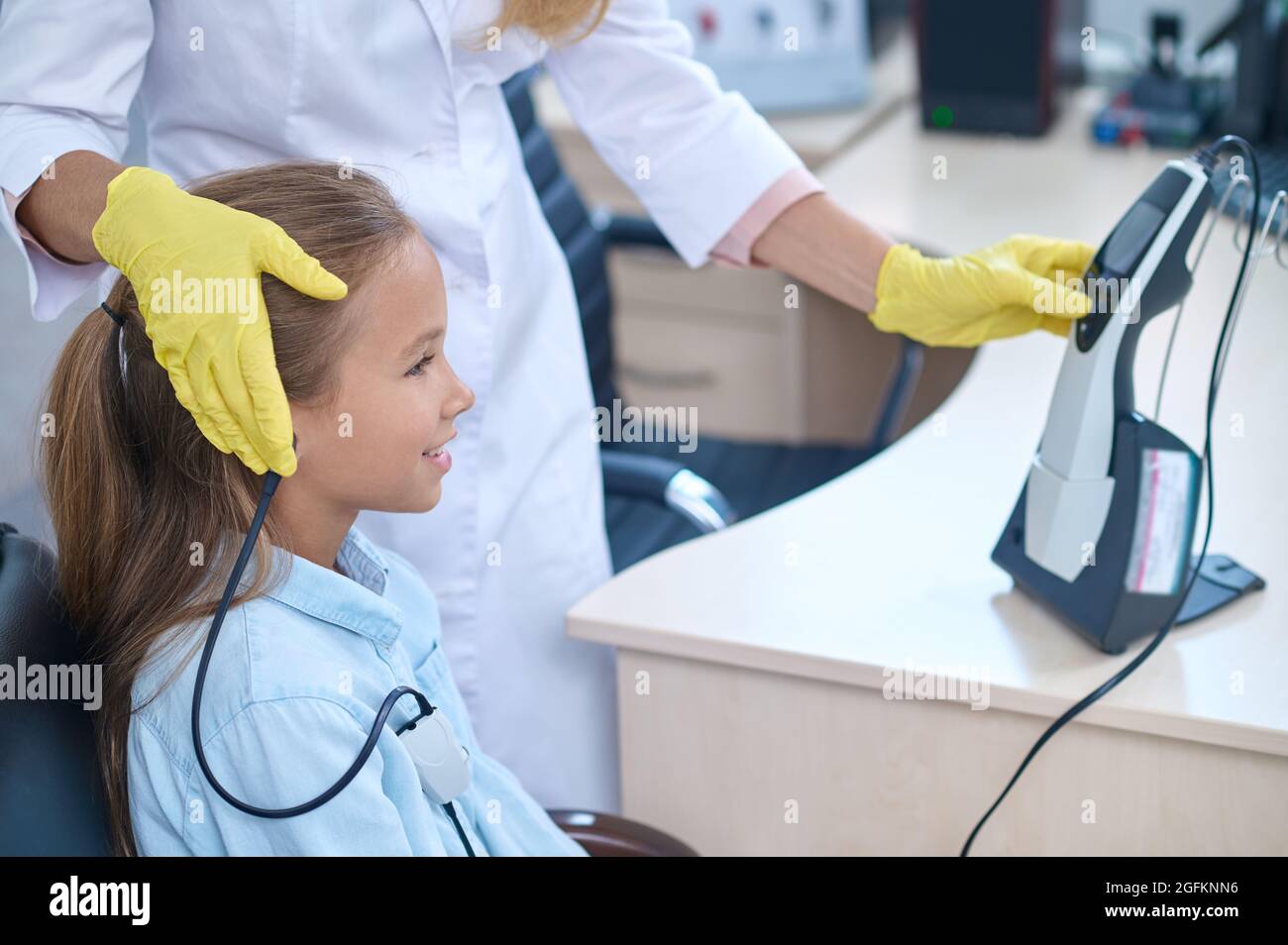 Pleased girl having her hearing checked on the audiometer Stock Photo