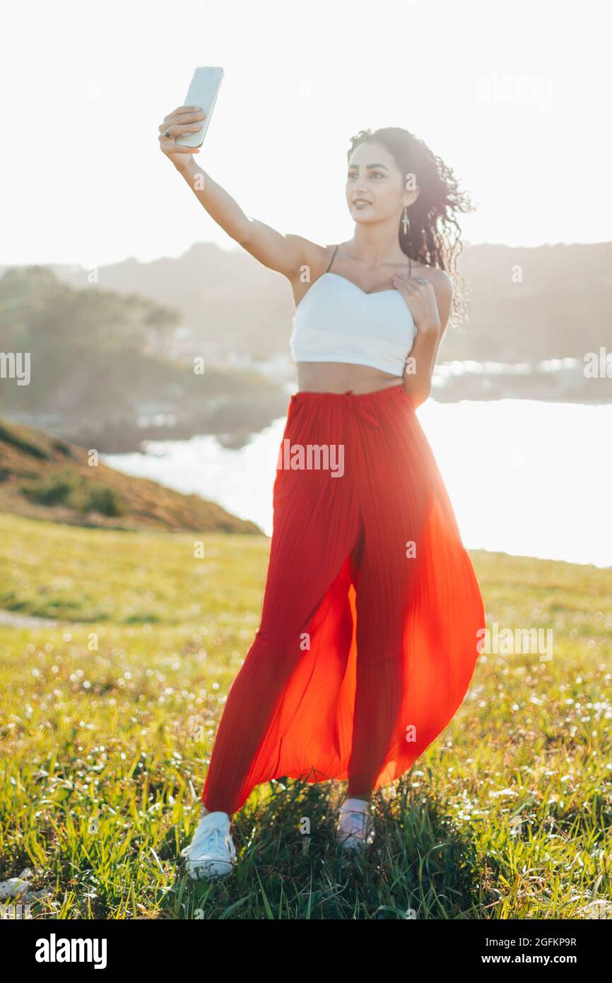 Candid portrait of stylish young woman taking a selfie with mobile