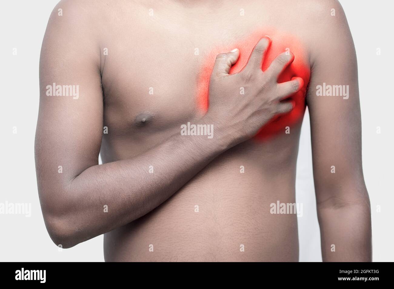 a black man holding his chest by hand for chest pain. Stock Photo