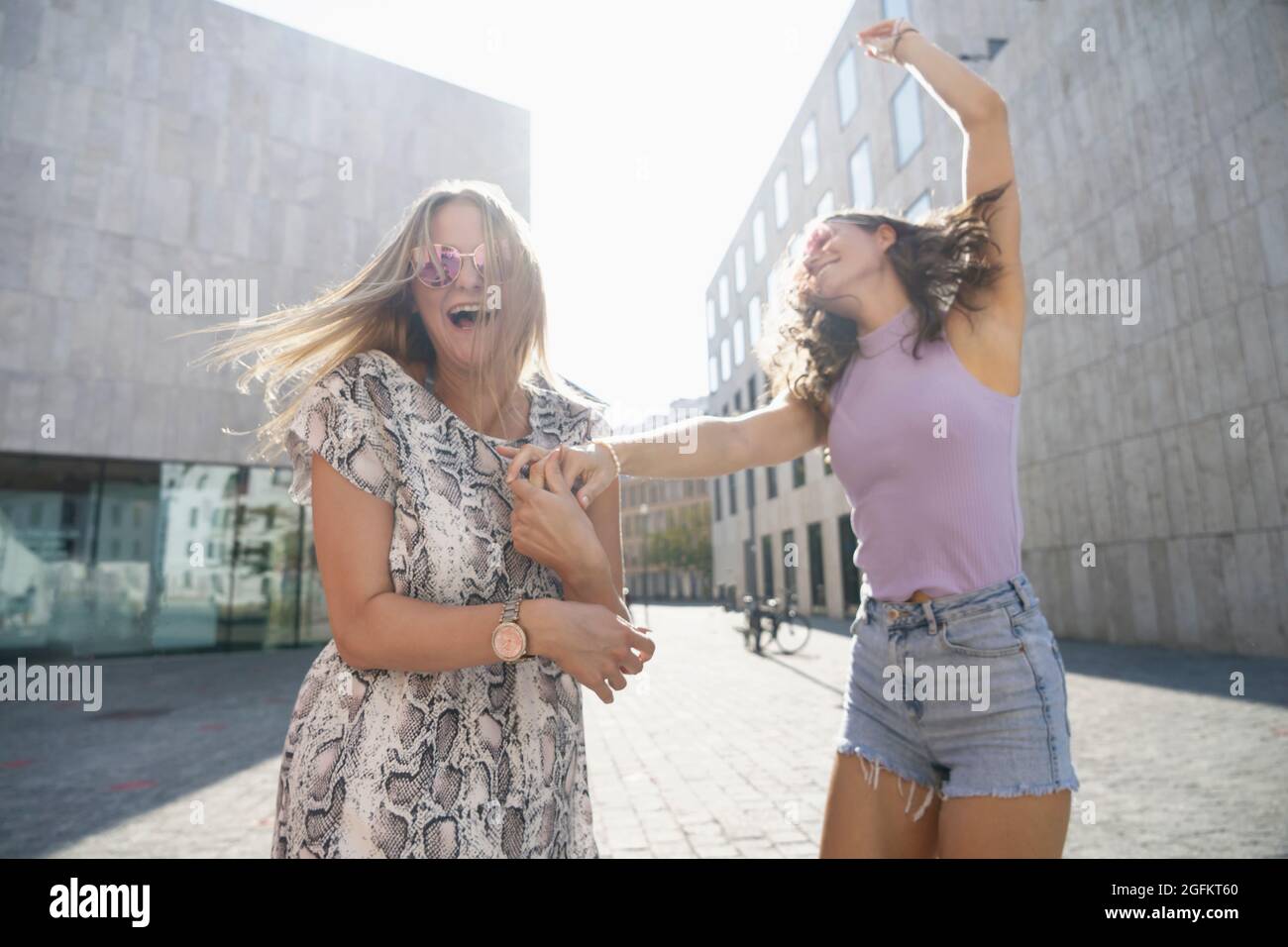 two young happy women dancing in the city of Munich Stock Photo