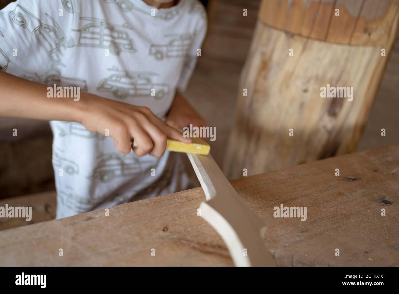Young boy using sander at carpentry workshop Stock Photo