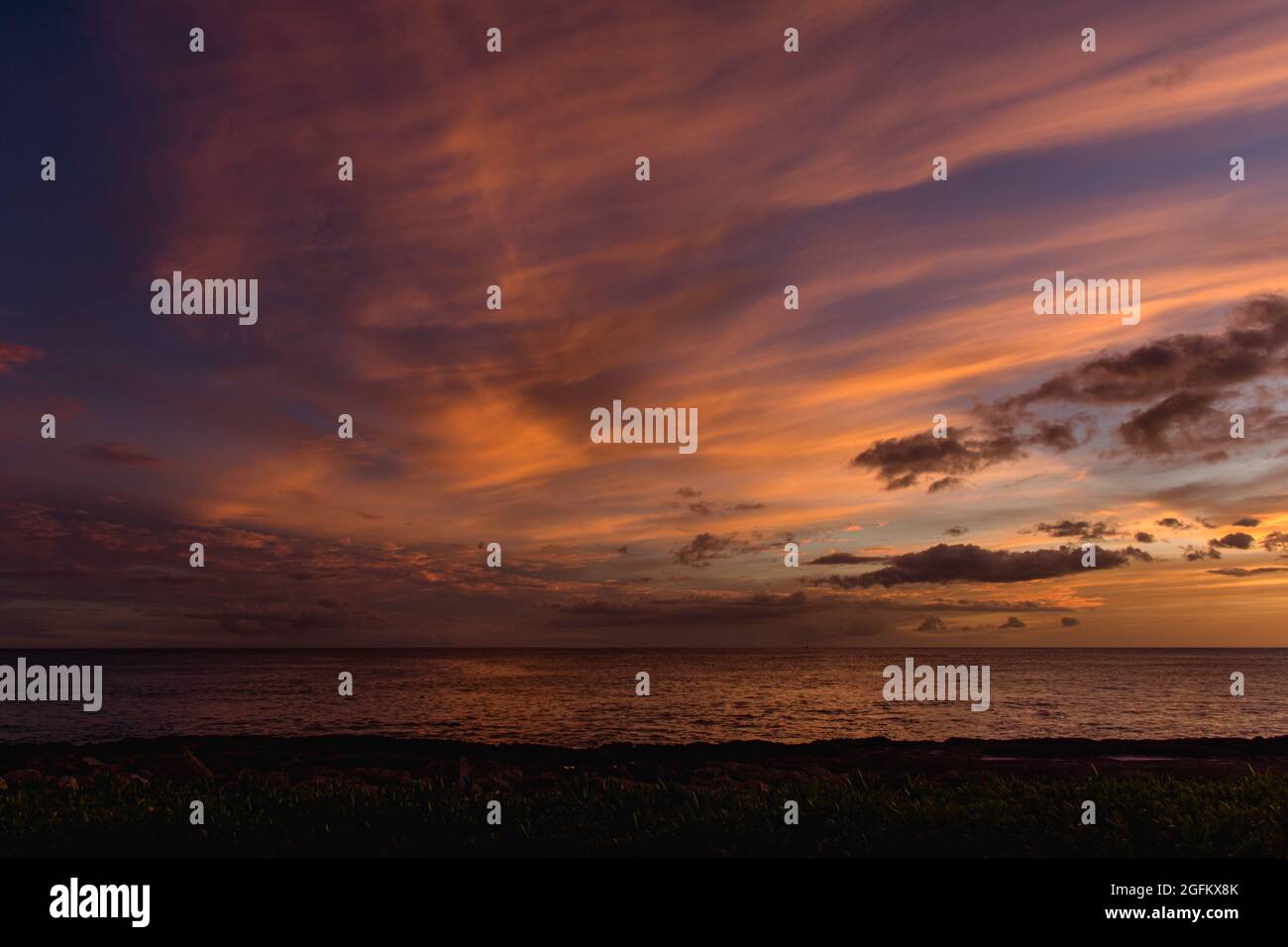 Rainbow Hawaiian cloudy sunset with silhouettes Stock Photo