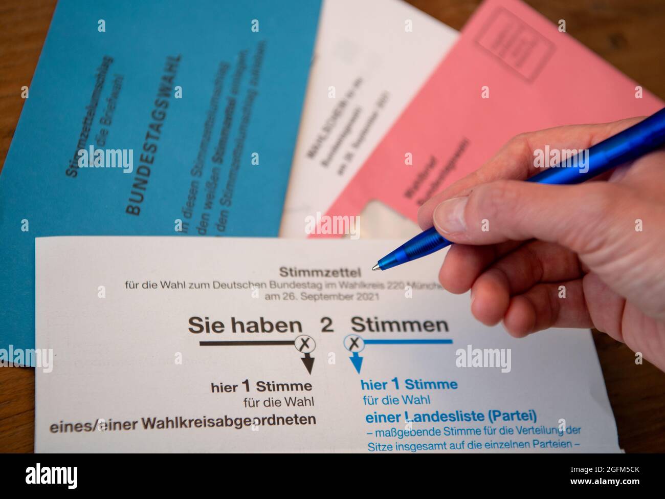 ILLUSTRATION - 26 August 2021, Bavaria, Munich: Absentee ballot papers for the 2021 federal election with ballot paper and ballot paper envelope lie on a table. Photo: Sven Hoppe/dpa Stock Photo