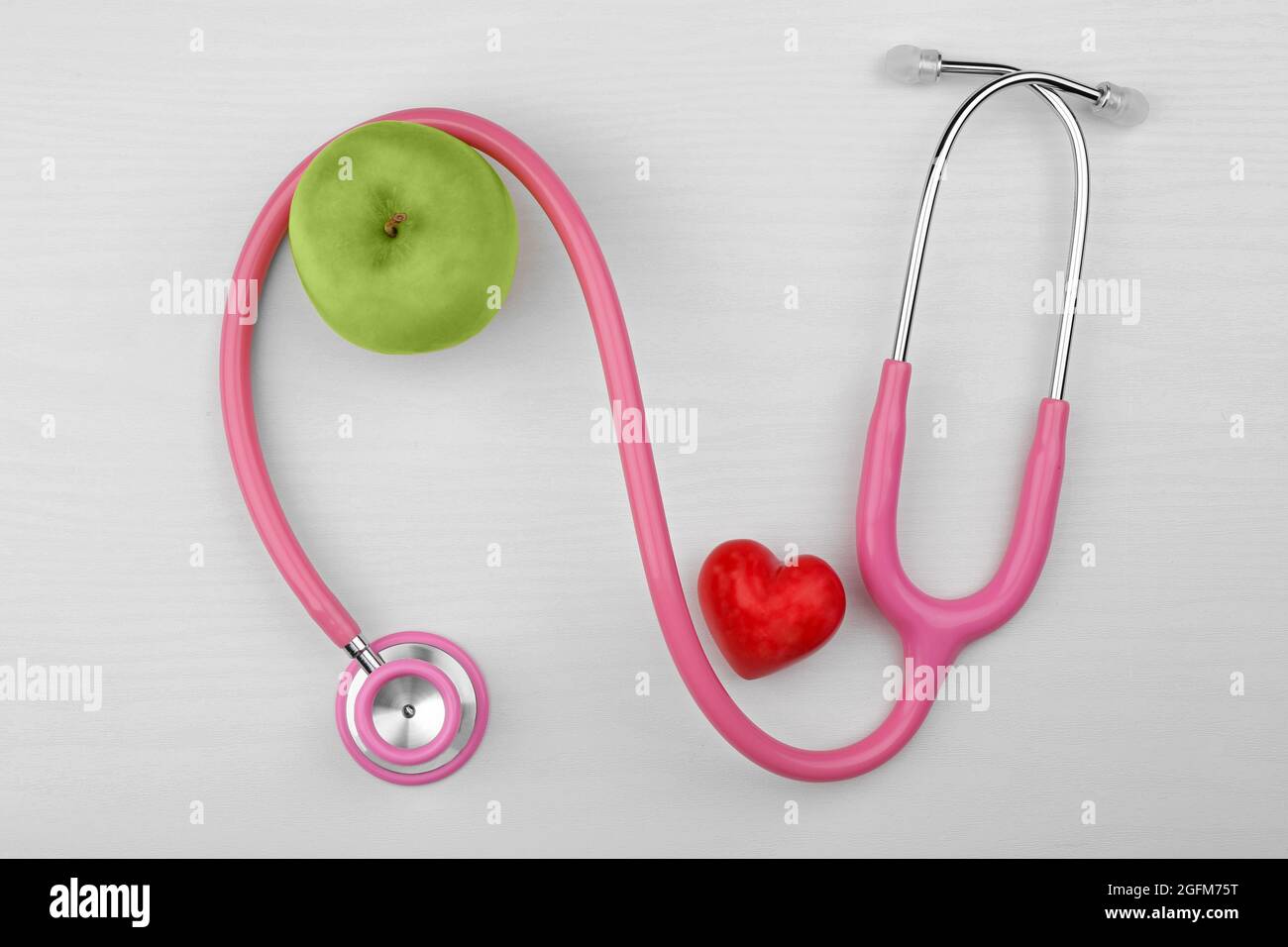 Stethoscope with apple and heart on white background Stock Photo - Alamy