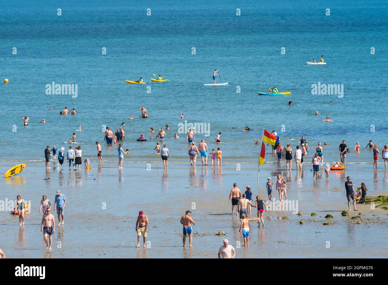 Lyme Regis, Dorset, UK. 26th Aug, 2021. UK Weather: Families and staycationers flock to the beach at the seaside resort of Lyme Regis to soak up the lovely warm sunshine and blue skies. The glorious weather is set to continue into the August Bank Holiday weekend. Credit: Celia McMahon/Alamy Live News Stock Photo