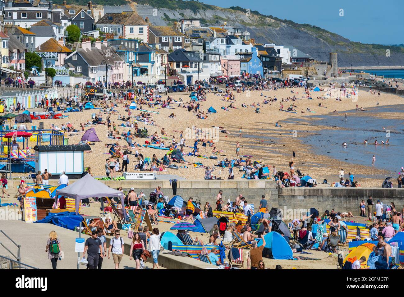Lyme Regis, Dorset, UK. 26th Aug, 2021. UK Weather: Families and staycationers flock to the beach at the seaside resort of Lyme Regis to soak up the lovely warm sunshine and blue skies. The glorious weather is set to continue into the August Bank Holiday weekend. Credit: Celia McMahon/Alamy Live News Stock Photo