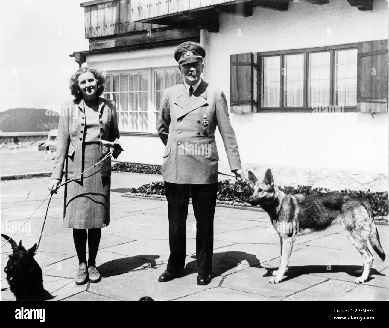 Adolf Hitler with his then girlfriend/mistress (later wife) Eva Braun with their dogs at the Berghof Alpine house. Credit: German Bundesarchiv Stock Photo