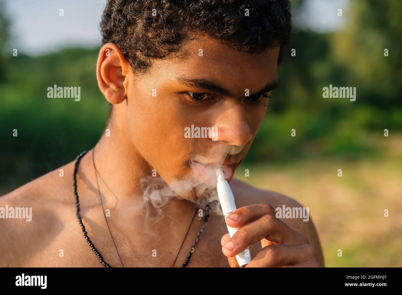 African American man smoking electronic cigarette with e-liquid outdoors  Stock Photo - Alamy