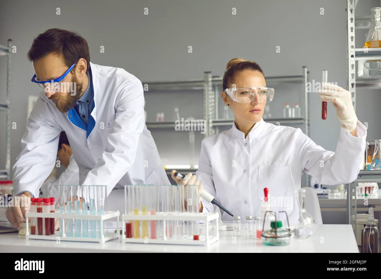 Team of Medical Research Scientist Conducts Experiments in Laboratory with Microscope Stock Photo