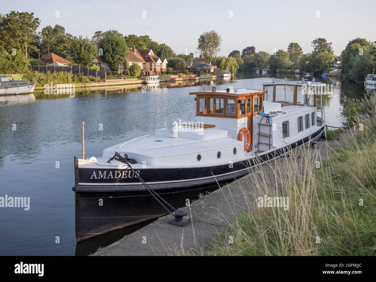 moored boats and houses on the banks of  the river thames at laleham in surrey Stock Photo