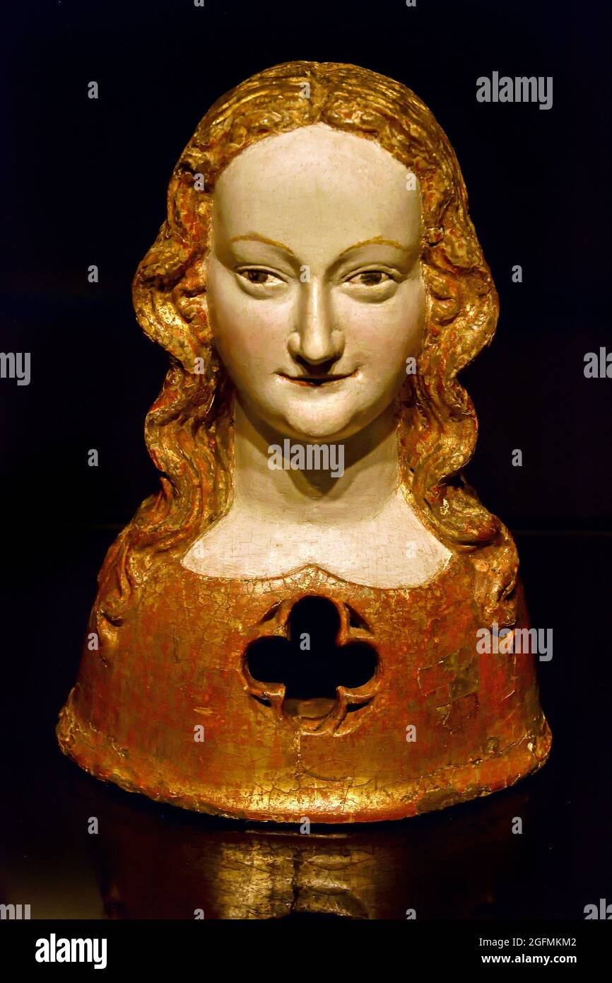 Reliquary bust of one of Saint Ursula’s virgins  1325 - 1349 anonymous,  walnut (hardwood),  26.6cm, German, Germany,   (According to legend, the Christian princess Ursula and her retinue of 11000 virginal handmaidens were murdered near Cologne by Huns. Their numerous relics were preserved in the basilica of St Ursula and other churches in Cologne, particularly in wooden reliquary busts such as this. The victim’s relics could be seen by the faithful through the opening in the bust. Stock Photo