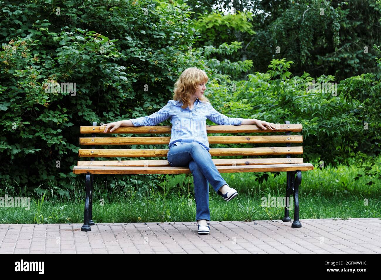 Girl sitting alone in a park bench hires stock photography and images