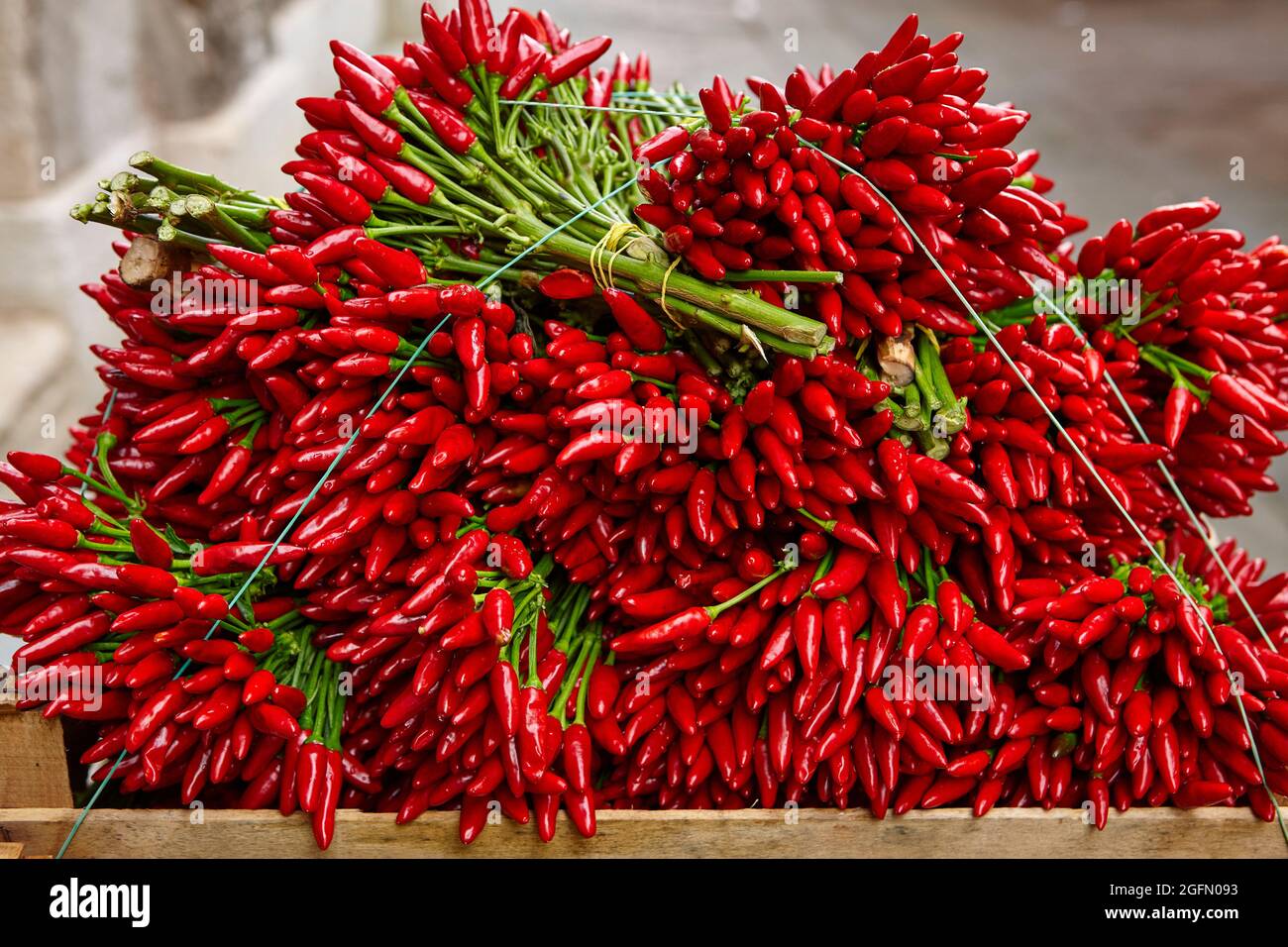 Pile of harvested red chili peppers on market stall Stock Photo