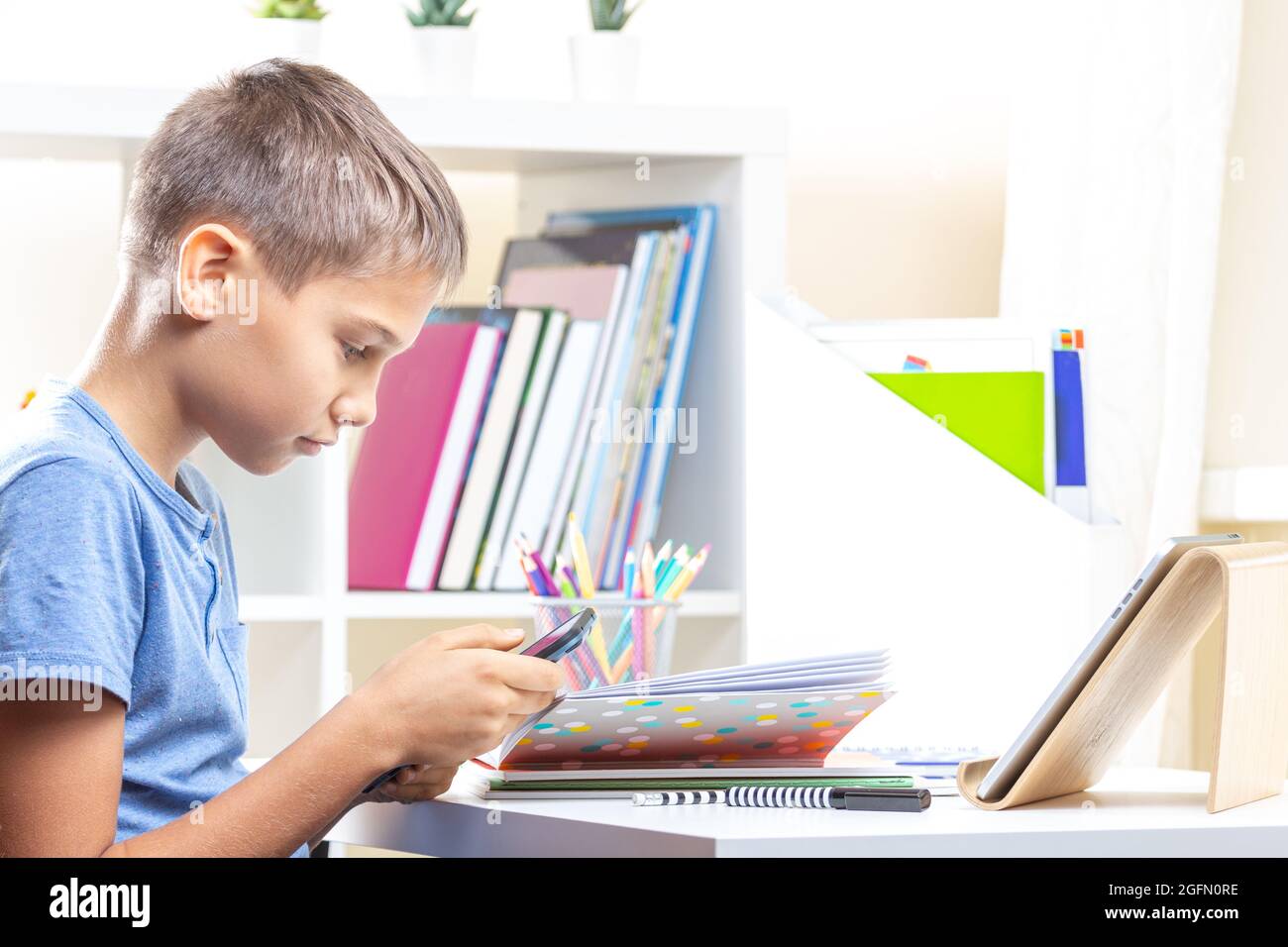 Teen boy distracting from online lesson and playing video games, scrolling  phone. Learning difficulties, online education, entertainment at home Stock  Photo - Alamy