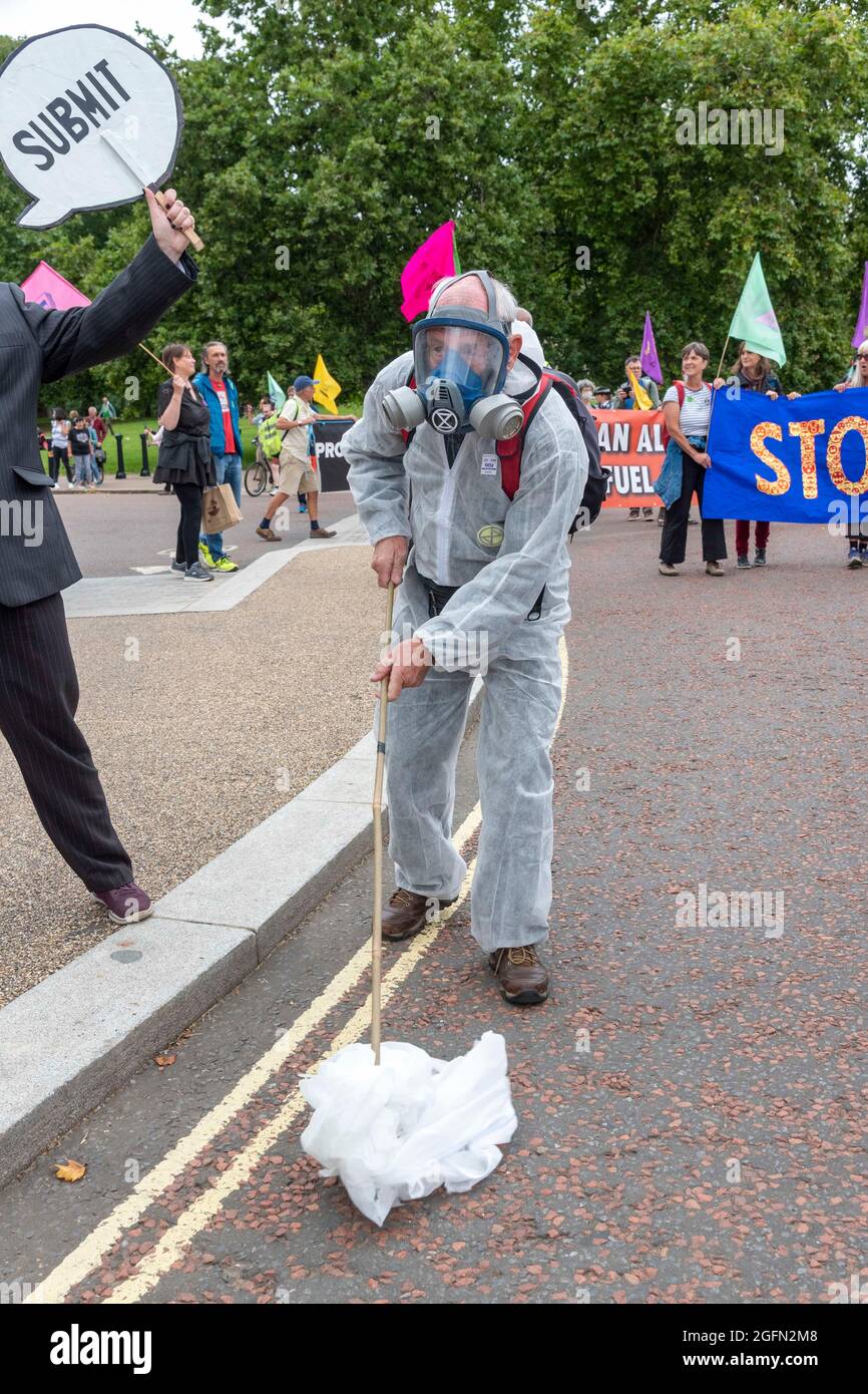 A protester seen wearing a protective suit and gas mask as he picks plastic from the ground during the protest.Extinction Rebellion's Impossible Rebellion protest continues as protesters march from Hyde Park in London under the theme 'Stop The Harm' against climate change, global warming, and plans to target the root cause of the climate and ecological crisis and to demand the government divest from fossil fuel companies. (Photo by Dave Rushen / SOPA Images/Sipa USA) Stock Photo