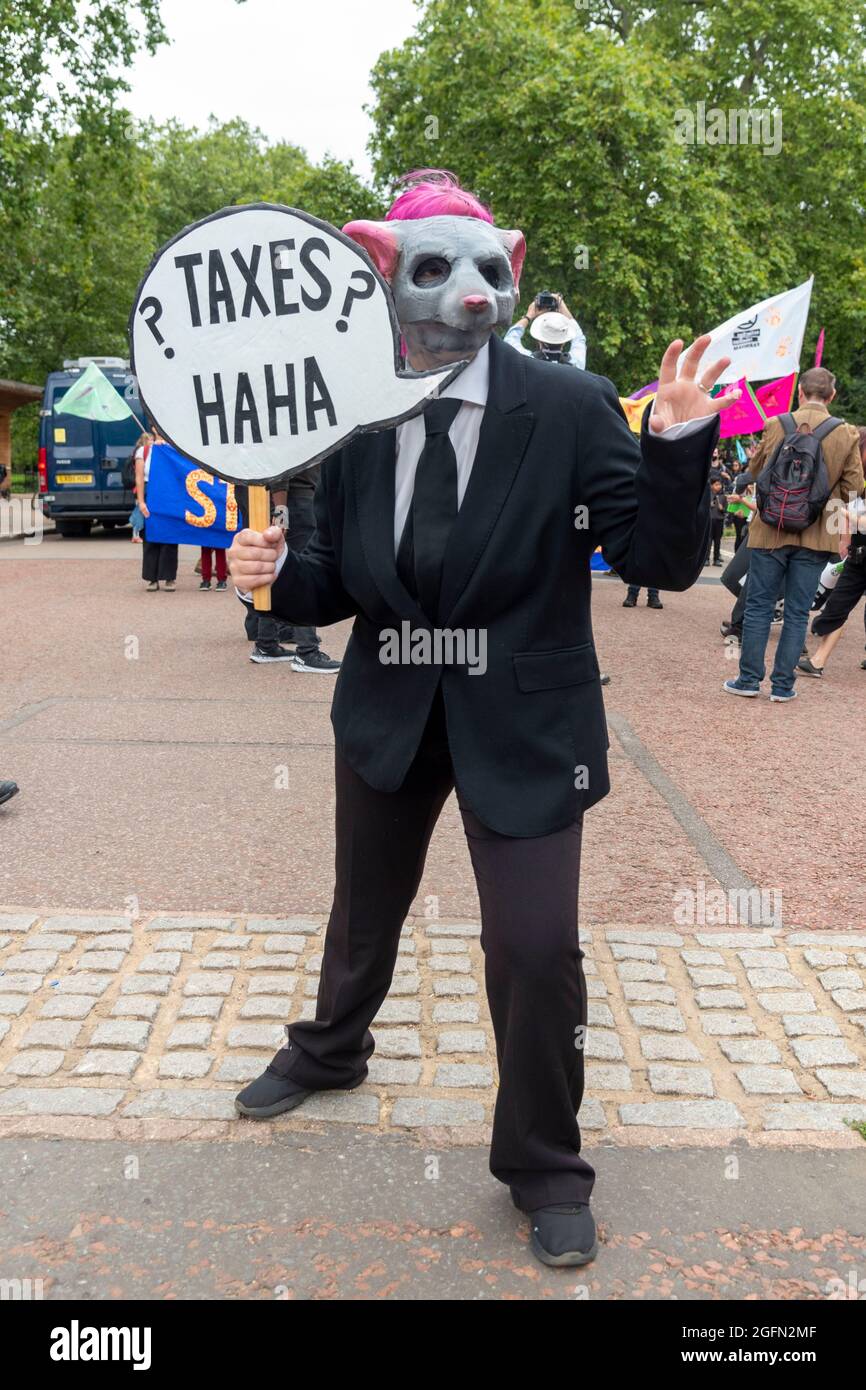 A protester seen wearing a costume and holding a speech bubble saying ’Taxes haha’ seen during the protest.Extinction Rebellion's Impossible Rebellion protest continues as protesters march from Hyde Park in London under the theme "Stop The Harm" against climate change, global warming, and plans to target the root cause of the climate and ecological crisis and to demand the government divest from fossil fuel companies. (Photo by Dave Rushen / SOPA Images/Sipa USA) Stock Photo