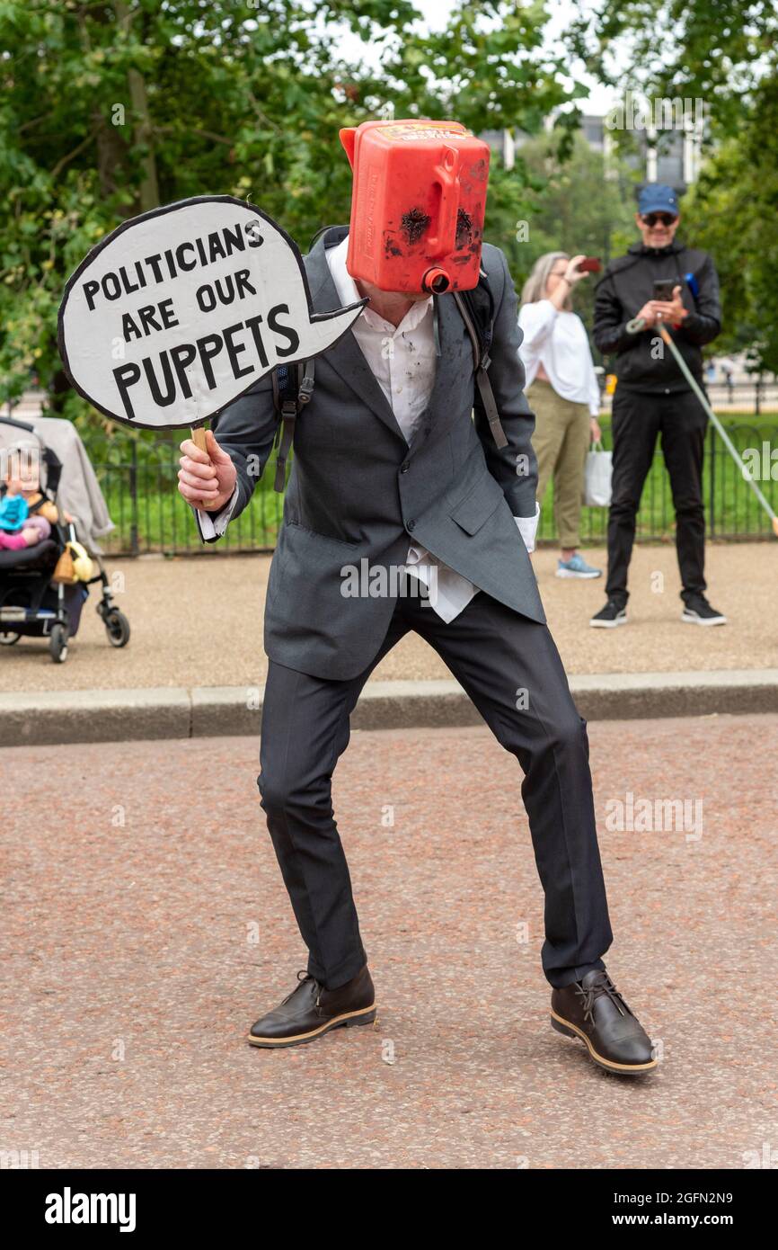 A protester is seen with an oil can on his head and holding speech bubble reading 'politicians are puppets' during the protest.Extinction Rebellion's Impossible Rebellion protest continues as protesters march from Hyde Park in London under the theme 'Stop The Harm' against climate change, global warming, and plans to target the root cause of the climate and ecological crisis and to demand the government divest from fossil fuel companies. (Photo by Dave Rushen / SOPA Images/Sipa USA) Stock Photo