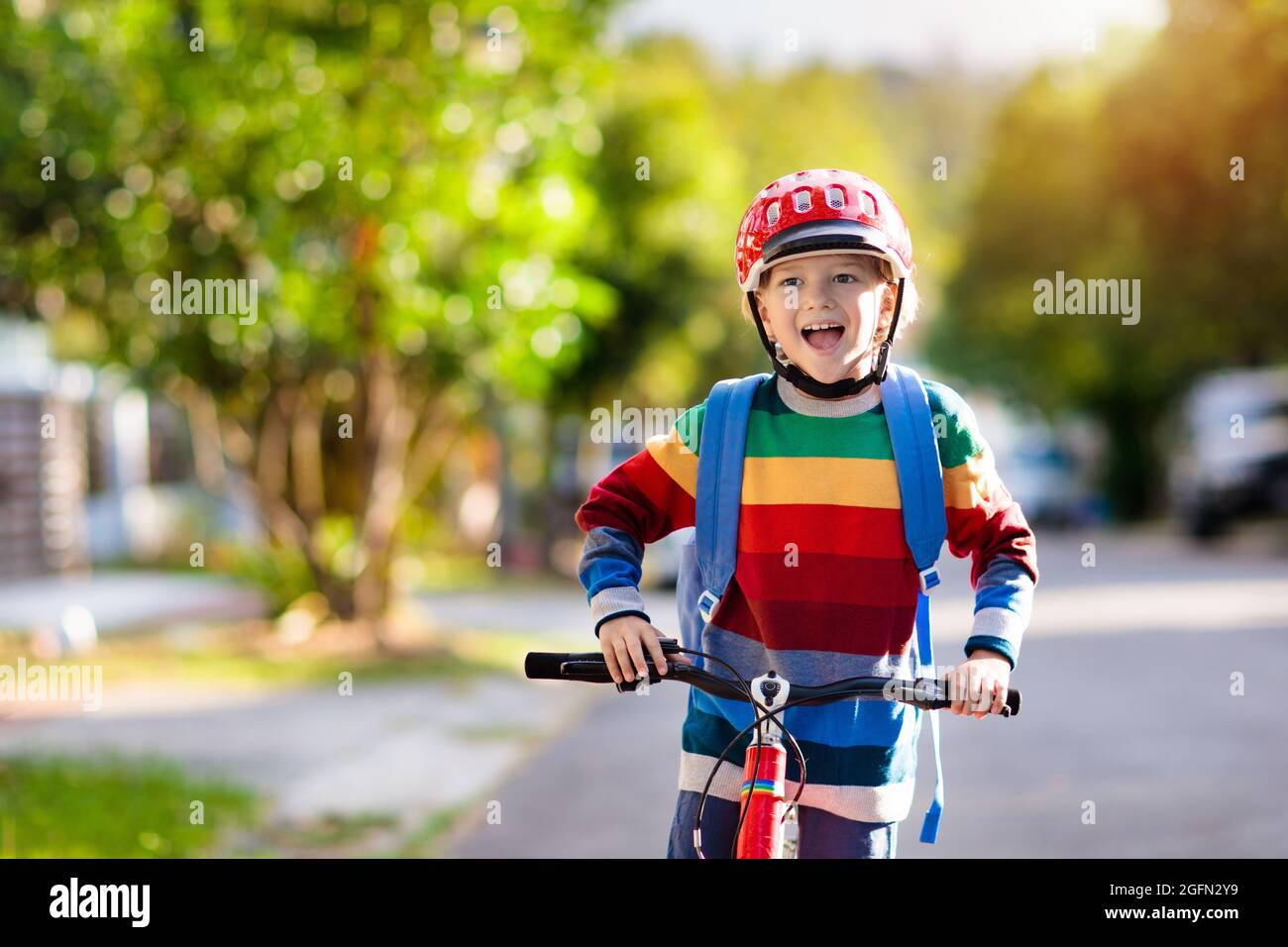 Child going to school on bike. Kids ride bicycle. Safe way to elementary school. Little boy with