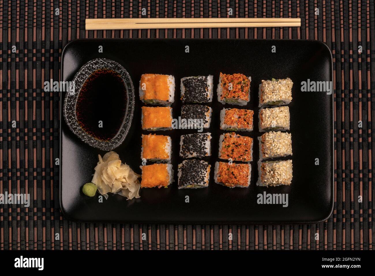 variety of sushi rolls served with soy sauce on a table Stock Photo