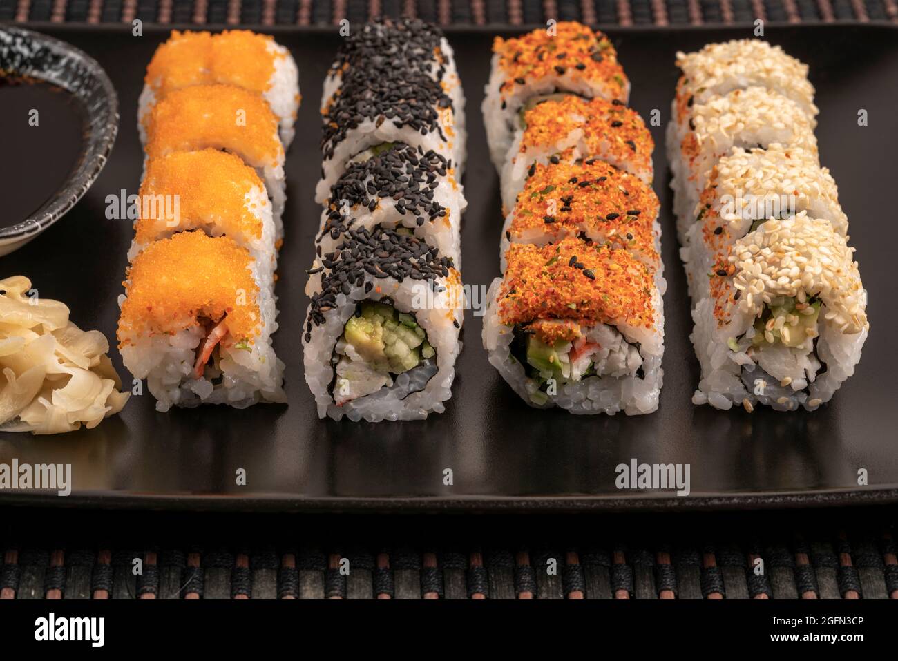 variety of sushi rolls served with soy sauce on a table Stock Photo