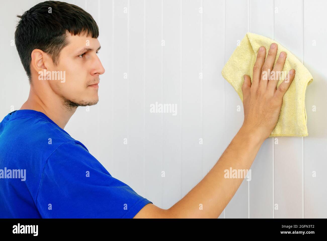 Hand With Rag A man with a rag in his hand washes the wall inside the room ...