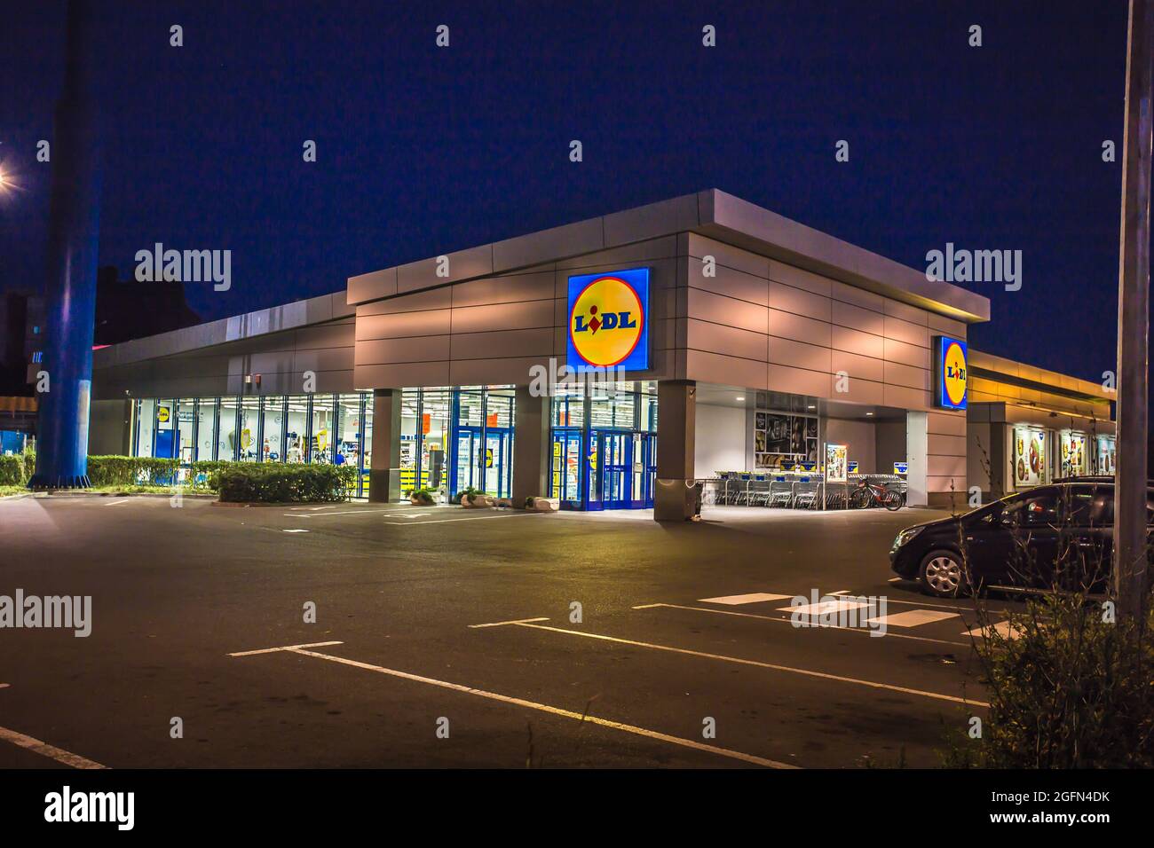 View of Lidl supermarket and logo in the night.Lidl Stiftung & Co. KG is a German global discount supermarket chain,operating in 26 European countries Stock Photo