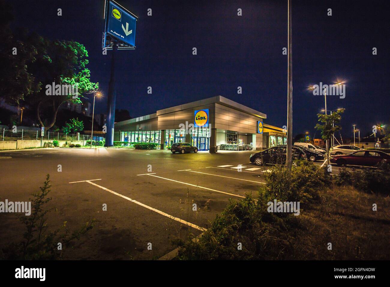 View of Lidl supermarket and logo in the night.Lidl Stiftung & Co. KG is a German global discount supermarket chain,operating in 26 European countries Stock Photo