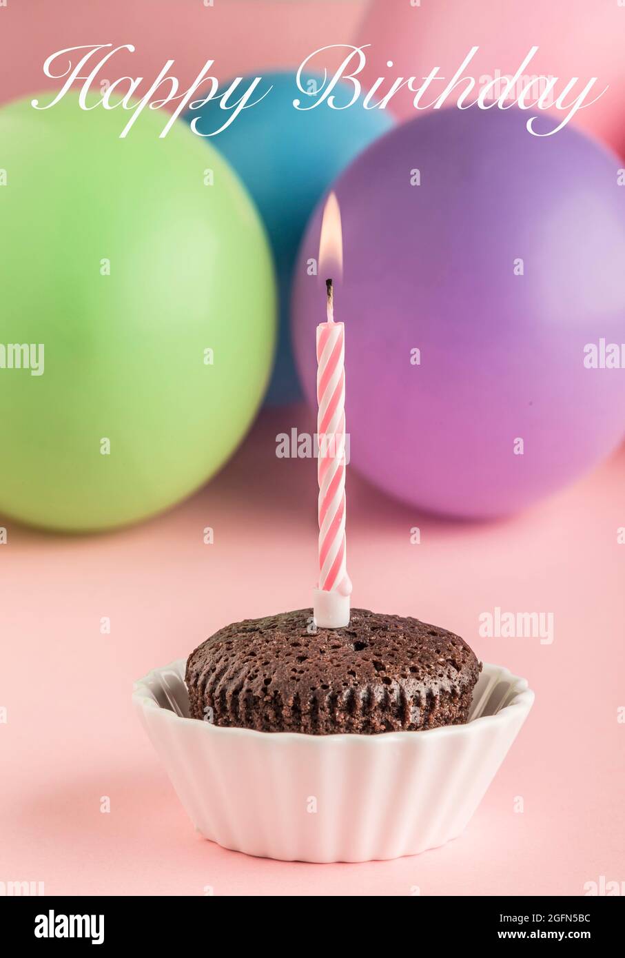 A small birthday cake with one candle on pink Stock Photo Alamy