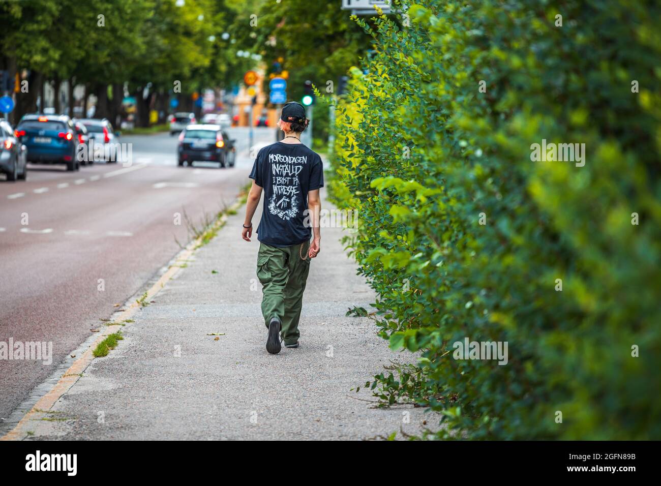 Young man walking along road hi-res stock photography and images - Alamy