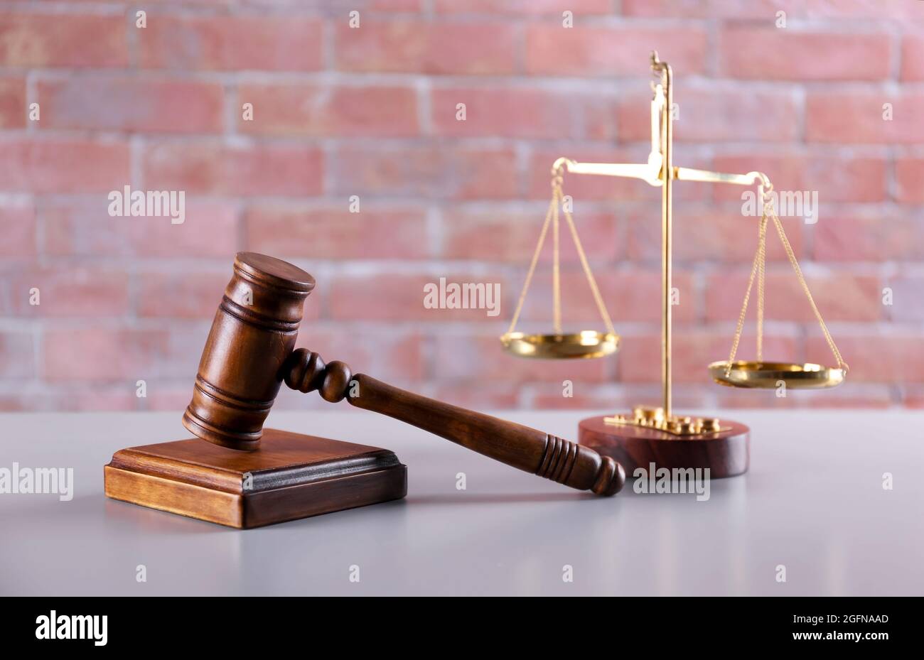 Gavel with sound block and scales on brick wall background Stock Photo