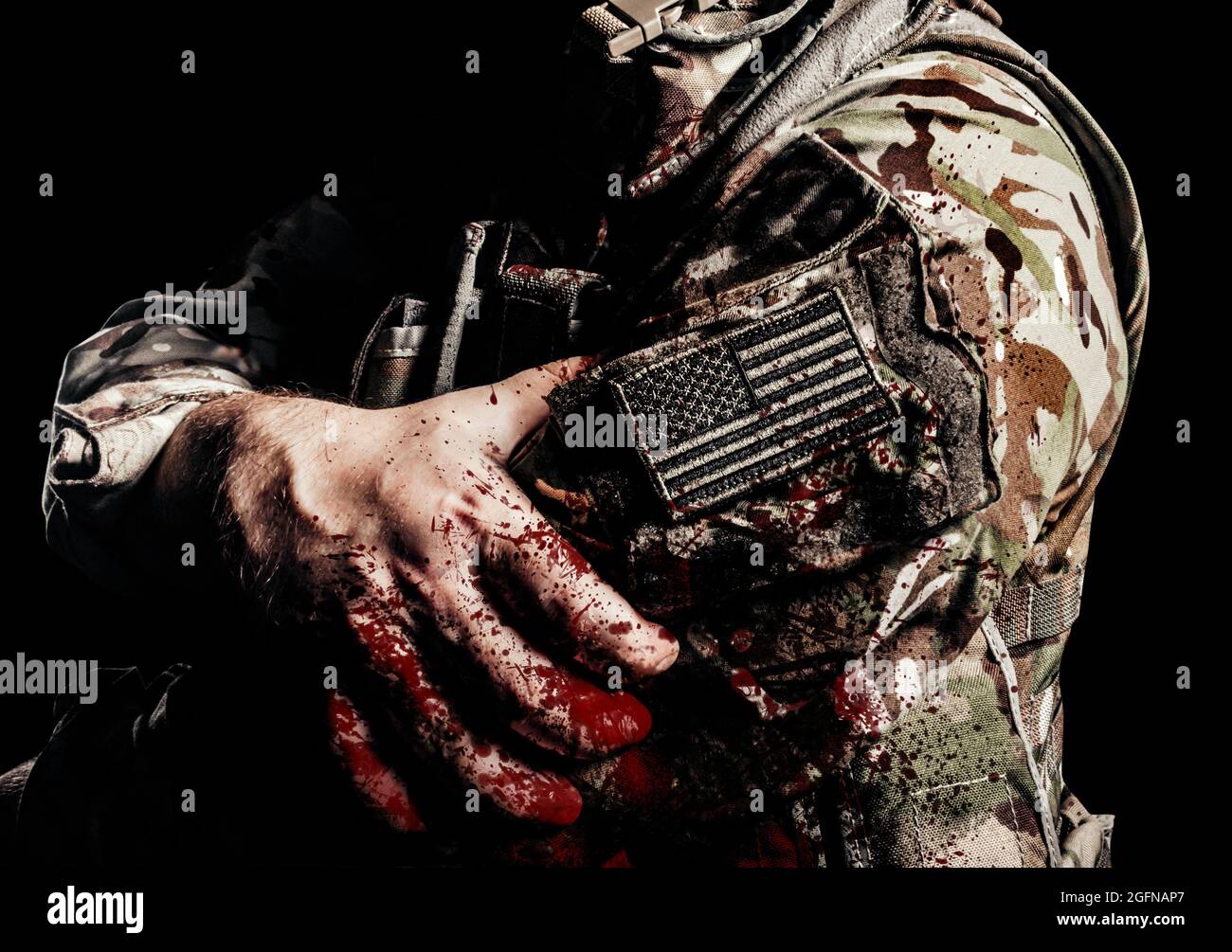 Photo shaded and wounded american soldier in uniform with usa patch on arm and blood splatter on it. Stock Photo