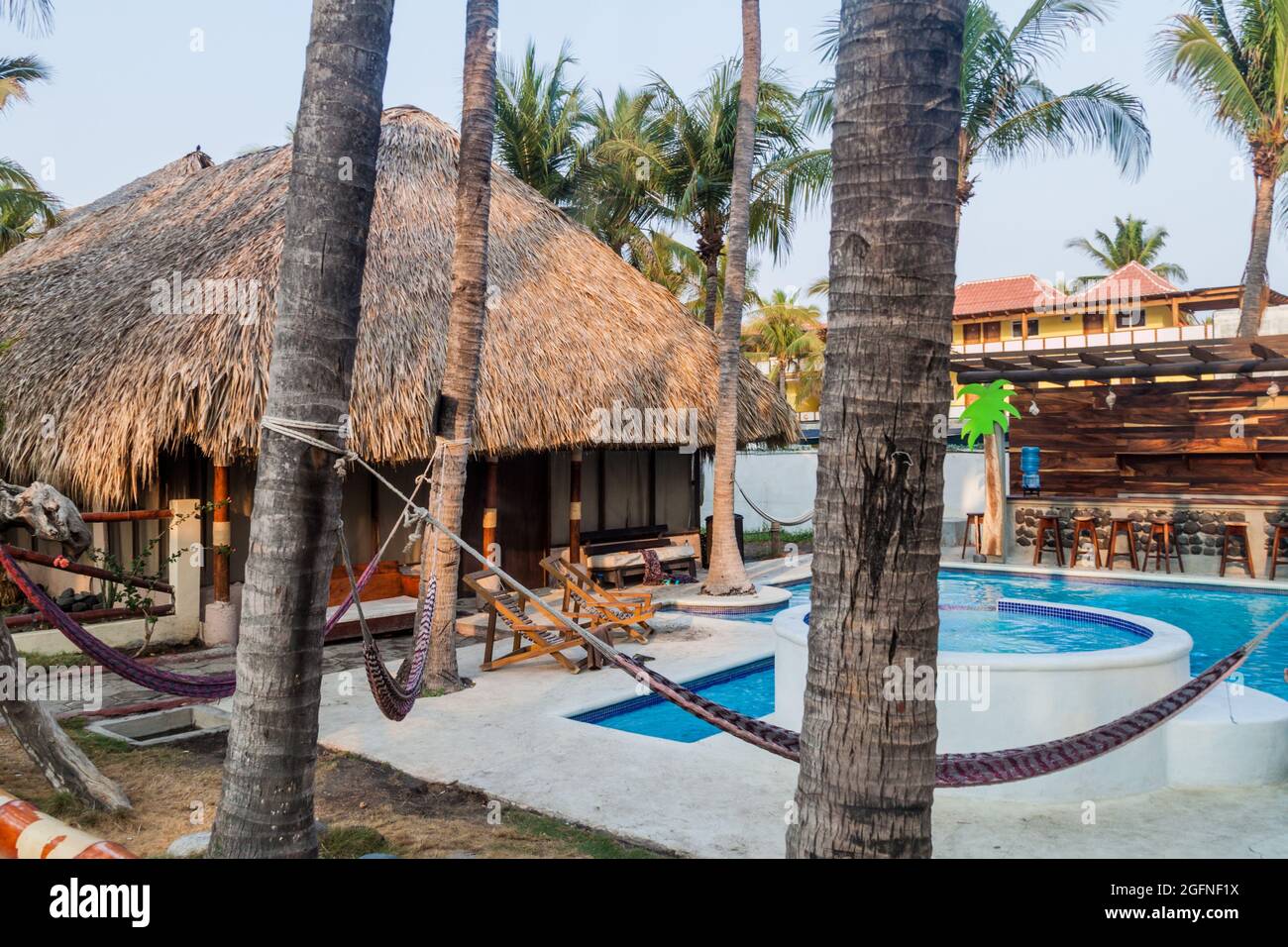 MONTERRICO, GUATEMALA - MARCH 29, 2016: Thatched hut, hammocks and a pool in Johnny's Place hotel in Monterrico village. Stock Photo