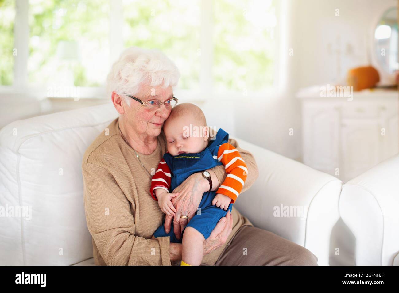 Grandmother holding newborn baby. Family reunion. Senior woman with