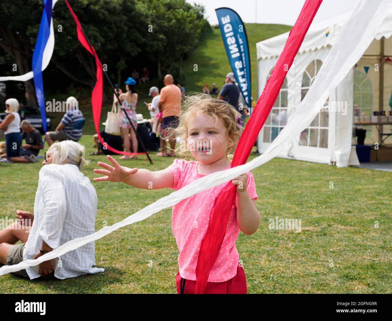 Young child playing with flag ribbons at festival, Cornwall, UK Stock ...