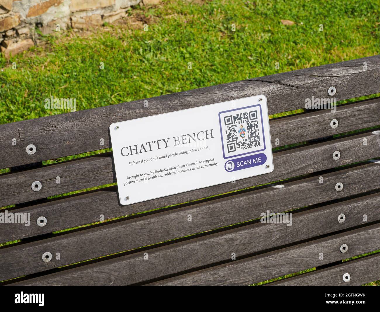 Chatty bench, The bench serves as a place where people can go and sit and don’t mind others sitting for a chat as well. QR codes on the plaque take u Stock Photo