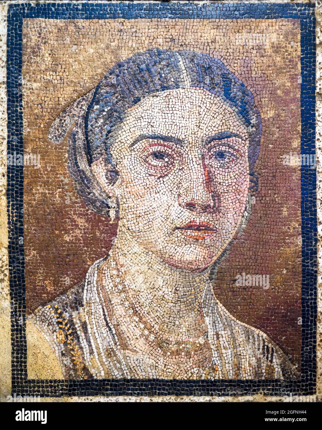 Female portrait Mosaic emblema in opus vermiculatum made from polychrome  tesserae. The panel shows a woman with well defined features. Her hair is  centrally parted and she wears jewellery, details that date